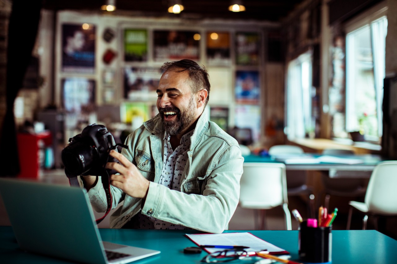 Close up of a photographer using his camera in an office